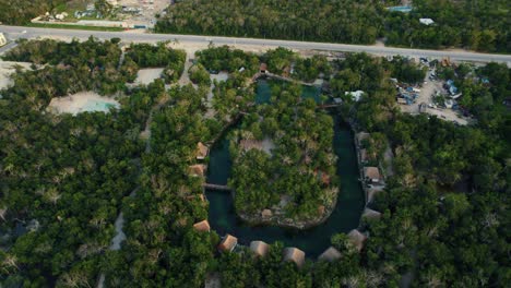 Vista-Aérea-Del-Paisaje-De-Lujosas-Casas-De-Madera-En-La-Playa-En-Un-Complejo-Tropical-Rodeado-De-árboles,-En-Tulum,-México