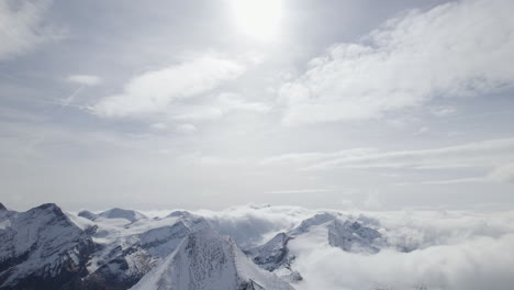 Luftaufnahme-Nach-Unten-Schneebedeckte-Berggipfel-Beleuchtung-Durch-Sonnenlicht-Und-Blau-Gefärbter-See-Im-Tal---Zell-Am-See,-Kitzsteinhorn-In-Österreich