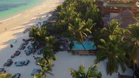 Drone-view-of-a-relaxing-tourist-along-a-beautiful-Akiin-Beach,-Tulum,-Mexico