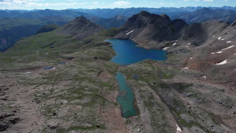 Aerial-View-of-Glacial-Lake-Under-Hills-of-Rocky-Mountains-National-Park,-Colorado-USA