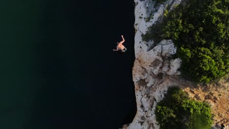 Man-running-on-top-of-cliff-and-jumping-to-the-water