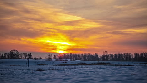 -Timelapse-shot-of-sunrise-over-snow-covered-rural-countryside-during-a-cold-winter-evening