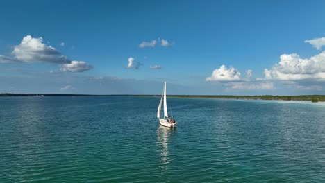 Aerial-view-orbiting-around-a-sailing-boat-on-the-lake-Bacalar,-in-sunny,-Mexico