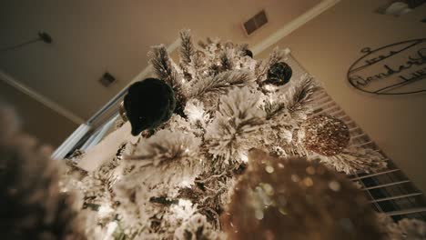 Drücken-Sie-Die-Aufnahme-Eines-Schneebeflockten-Weihnachtsbaums-Hoch,-Der-Alle-Ornamente-Und-Lichter-Zeigt,-Die-Darauf-Sind