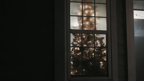 Ein-Weihnachtsbaum-Durch-Ein-Fenster,-Das-Im-Winter-Von-Außerhalb-Eines-Hauses-Geschossen-Wurde