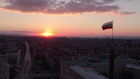 Sofia-Skyline,-Bulgaria,-Bulgarian-Flag-on-national-parliament-building-at-sunset