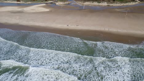 stunning-conil-beach-with-waves,-the-white-houses-in-the-background,-droneshot-with-sunny-weather