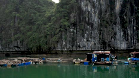 Tilt-down-from-the-sky-to-the-floating-village-where-fishermen-live-with-their-family-in-Halong-Bay,-Vietnam