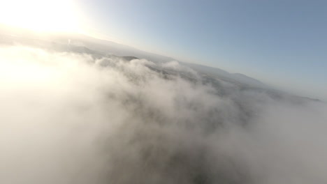 Fast-dreamlike-speeding-FPV-drone-flying-above-clouds-across-Alella-woodland-terrain,-Catalonia