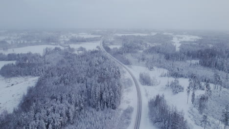 4K-areal-scenic-view,-drone-flying-over-highway-covered-with-snow-and-ice-during-snowfall
