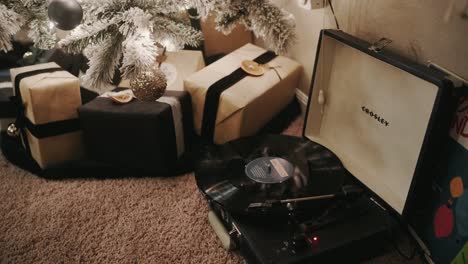record-player-playing-Christmas-music-right-next-to-a-Christmas-tree-with-presents-and-gifts-underneath
