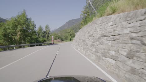 Driving-on-a-narrow-mountain-road-in-a-forest-in-the-Italian-Alps