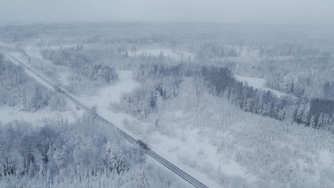 4K-areal-scenic-view,-drone-highway-over-rode-covered-with-snow-and-ice-during-snowfall