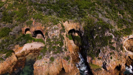 Drone-pullback-from-ancient-sea-caves-at-Featherbed-Nature-Reserve,-The-Heads