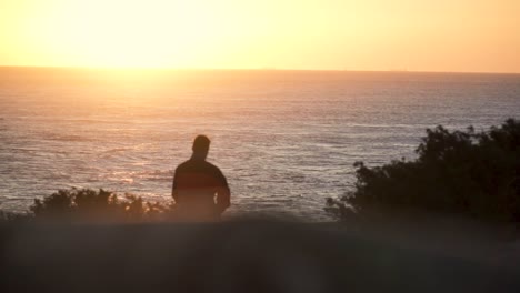Zeitlupenaufnahme-Eines-Mannes,-Der-Bei-Sonnenuntergang-In-Richtung-Meer-Geht,-Cadiz,-Spanien