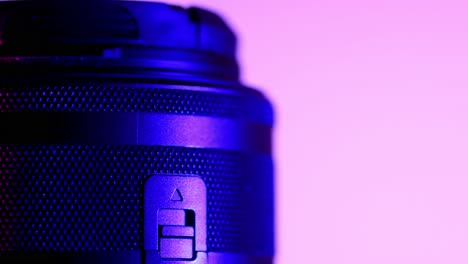 Macro-camera-lenses-studio-shot,-rotating-motion-with-blue-and-purple-lights