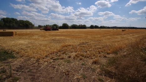 wide-shot-of-a-hey-field-with-tractor-making-hay-bales