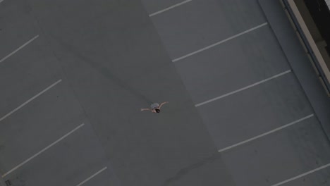 Drohnenabzug-Eines-Mädchens,-Das-Allein-Auf-Einer-Dachparkade-Tanzt