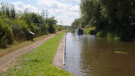 Red-narrowboat-entering-frame-on-the-Trent-and-Mersey-Canal-with-green-narrowboat-in-distance