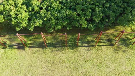 Old-rustic-pull-up-bar-in-local-park-gym,-aerial-view-on-sunny-day