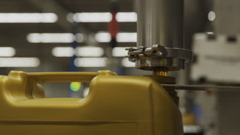 A-machine-depositing-oil-into-a-golden-plastic-jug