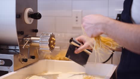Koch-Schneidet-Handgemachte-Spaghetti-Aus-Der-Maschine,-Zeitlupe