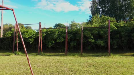 Old-Soviet-built-outdoor-gym-in-local-park,-dolly-backward-view