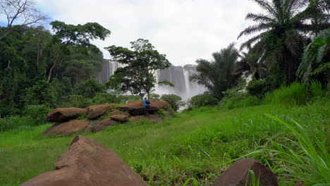 A-man-walking-towards-the-famous-Kalandula-waterfall-in-Angola,-Africa