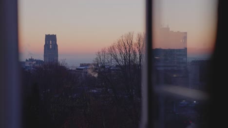 Timelapse-of-Wills-Memorial,-Bristol-during-the-sunrise-with-a-window-in-the-foreground