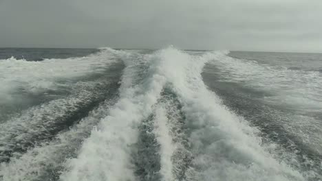 wake-of-water-seen-from-behind-of-fast-moving-motor-boat-in-a-clear-sky-day,Blue-sea-,-water-surface