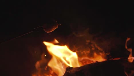 Closeup-Shot-of-Roasting-a-Marshmallow-Over-a-Campfire,-Slow-Motion