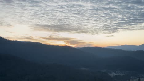 Bunter-Sonnenaufgang-Im-Wald-Mit-Sich-Bewegenden-Wolken-Im-Zeitraffer-Mit-Schichten-Und-Sonnenstrahlen