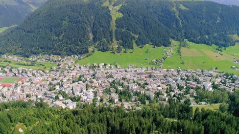 4K-aerial-shot-of-forrest-and-village-on-a-mountain-in-the-alps