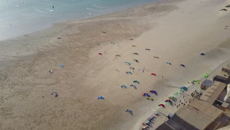 Drone-footage-of-kitesurf-kites-laid-out-on-the-beach-in-Dakhla,-Morocco