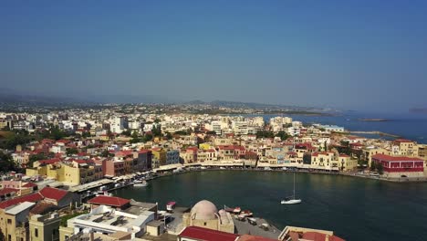 Dramatic-drone-footage-of-Chania,-Crete-elevating-above-red-rooftops-to-show-its-landscape