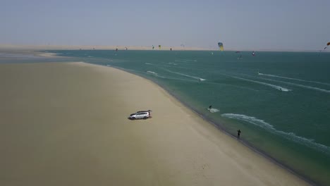 Drone-footage-of-kitesurfers-doing-jumps-and-surfing-on-the-beach-of-Dakhla,-Morocco