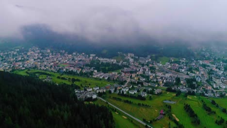 4k-Luftaufnahme,-Die-Bei-Sonnenaufgang-In-Einem-Dorf-In-Den-Alpen-über-Den-Wolken-Fliegt