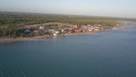 Drone-footage-of-tropical-beach-houses-on-the-coast-of-Ilha-do-Guajiru,-Brazil
