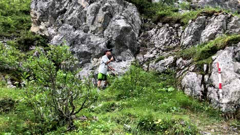 Cute-young-boy-climbing-up-some-stones-in-the-mountains