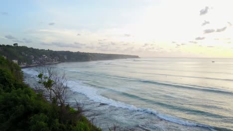 Drone-footage-of-waves-on-the-beach-in-Bali,-Indonesia-during-sunset