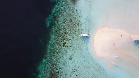 Drone-footage-a-tropical-beach-and-coral-reef-in-Raja-Ampat,-Indonesia