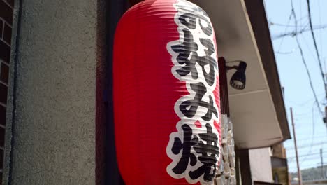 Cartel-De-Farol-Japonés-Tradicional-Colgado-Fuera-De-Un-Restaurante-En-Kyoto,-Japón-Iluminación-Suave-Cámara-Lenta-4k
