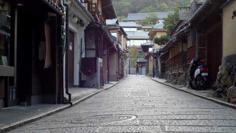Schöne-Straßen-Einer-Alten-Stadt-Am-Frühen-Morgen-Mit-Einem-Mädchen,-Das-In-Der-Ferne-In-Kyoto,-Japan,-Sanfte-Beleuchtung,-Zeitlupe-4k-Geht