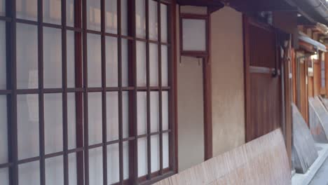 Walking-along-the-outsides-of-tradition-Japanese-restaurants-with-sliding-doors-in-Kyoto,-Japan-soft-lighting-slow-motion-4K