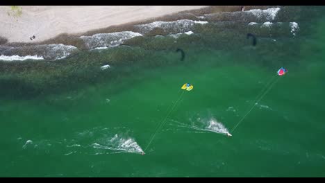 Drohne,-Die-Zwei-Drachenboardern-Am-Strand-Im-Meer-Von-Galiläa,-Israel,-Folgt