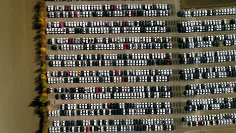 Aerial-footage-of-finished-cars-ready-to-be-shipped-on-huge-distribution-center