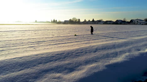 Little-boy-playing-with-a-ball-in-field-full-of-snow