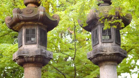 Tiro-De-Diapositiva-De-Linternas-De-Piedra-En-Un-Templo-En-Kyoto,-Cámara-Lenta-De-Japón-4k