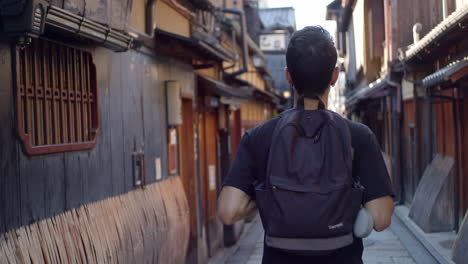 Person-walking-through-a-Japanse-allyway-early-in-the-morning-in-Kyoto,-Japan-soft-lighting