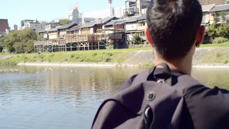 Kerl-Sitzt-An-Einem-Fluss-In-Kyoto,-Japan-Sanfte-Beleuchtung